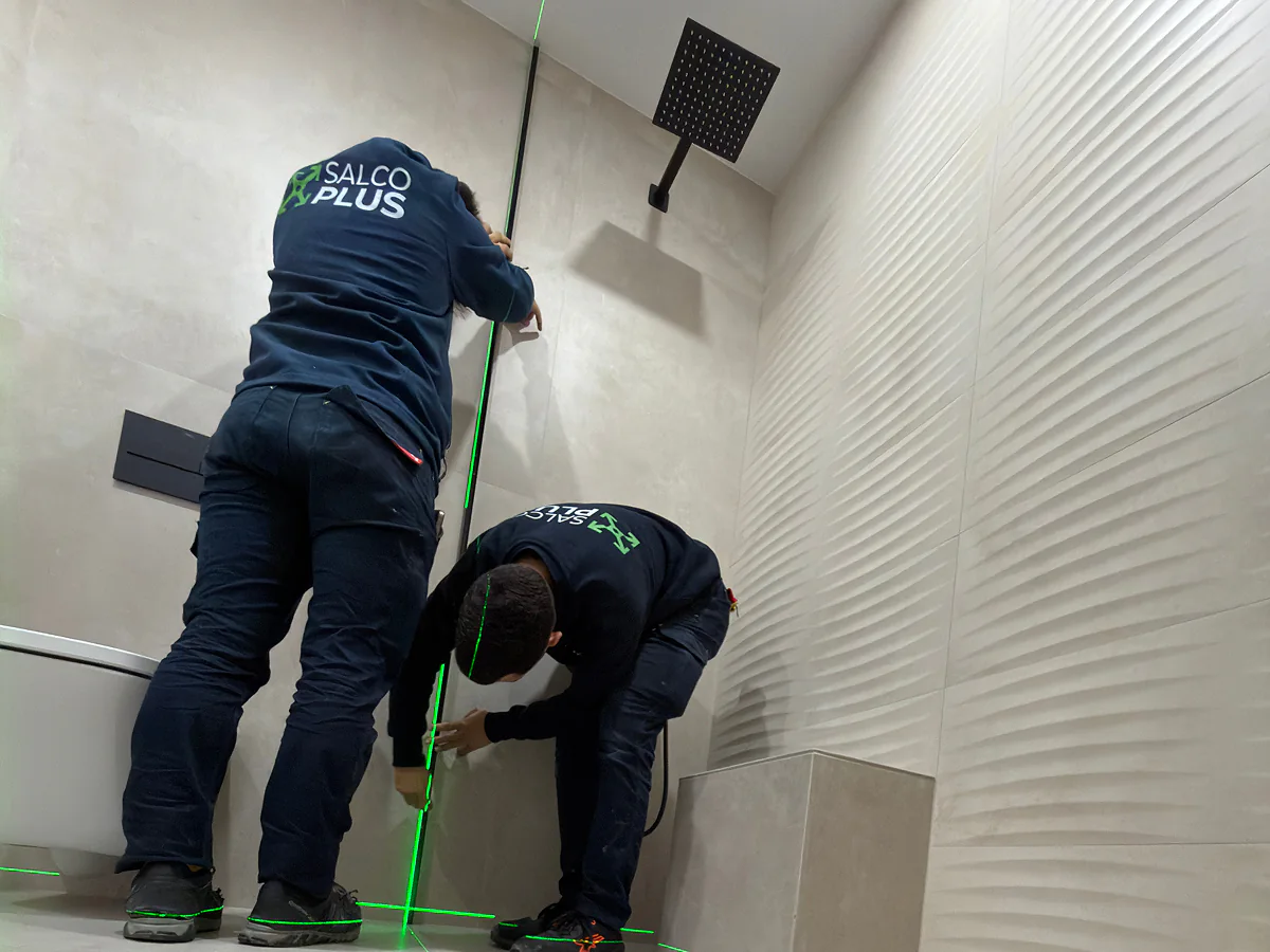 Equipo de SALCOPLUS nivelando con láser para montaje de mampara a medida