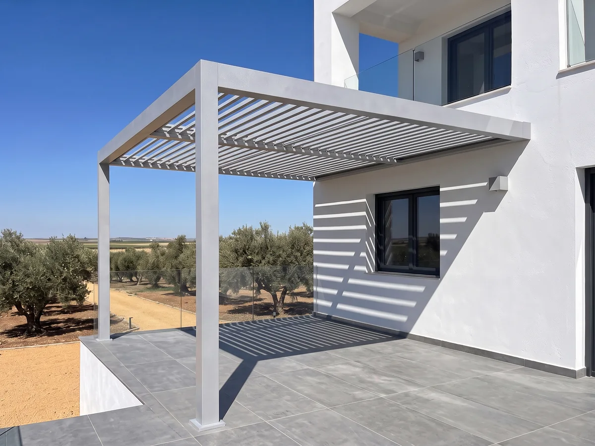 Pérgola bioclimática adosada de aluminio blanco con lamas orientables en terraza en Sevilla