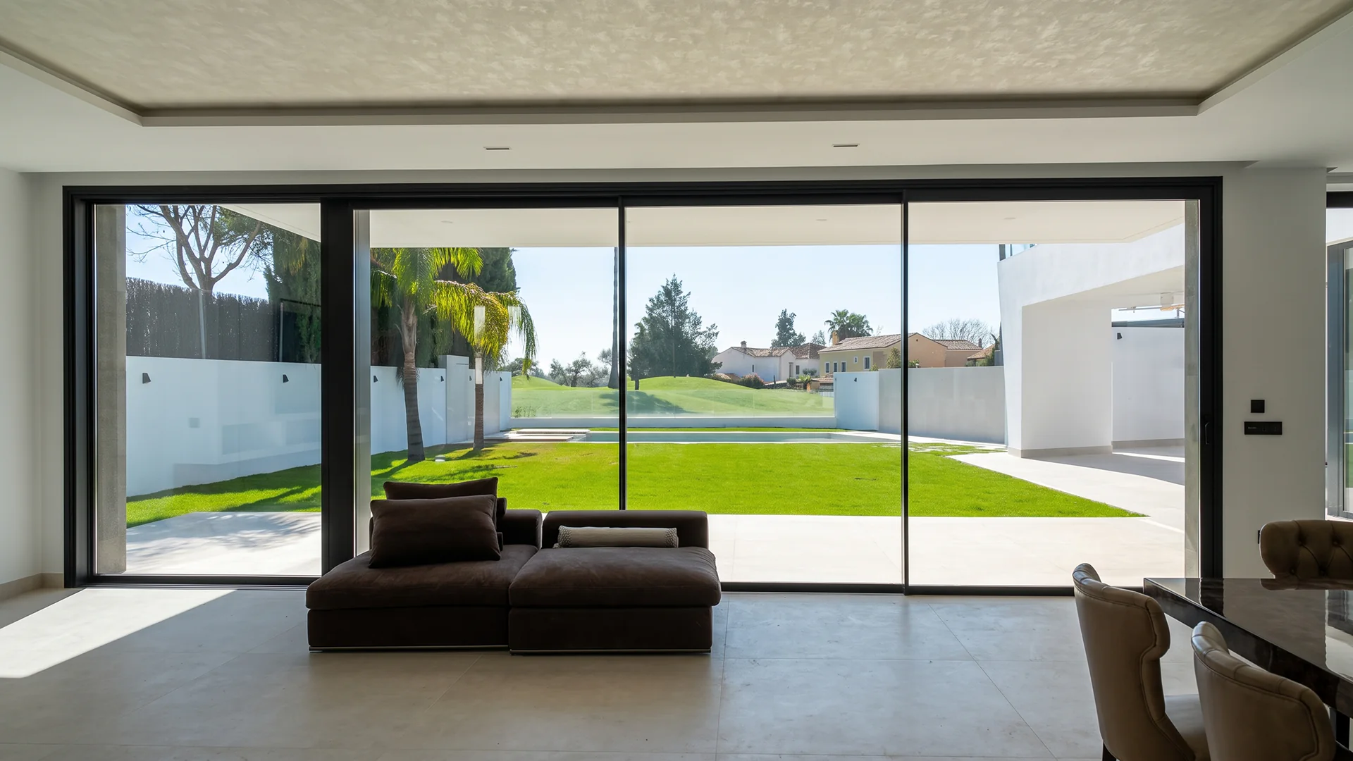Cerramiento de terraza con puertas correderas de cristal de gran formato y vistas al jardín en Sevilla