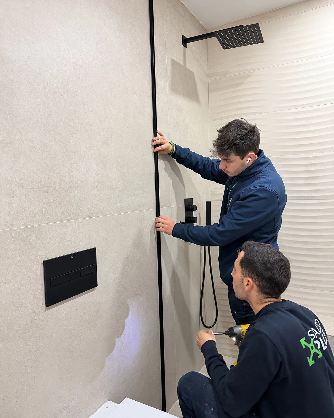 Instaladores de SALCOPLUS ajustando la perfilería de una mampara a medida