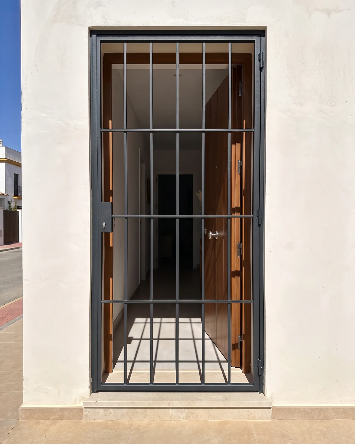 Reja de protección abatible para acceso de vivienda instalada por SALCOPLUS en Sevilla