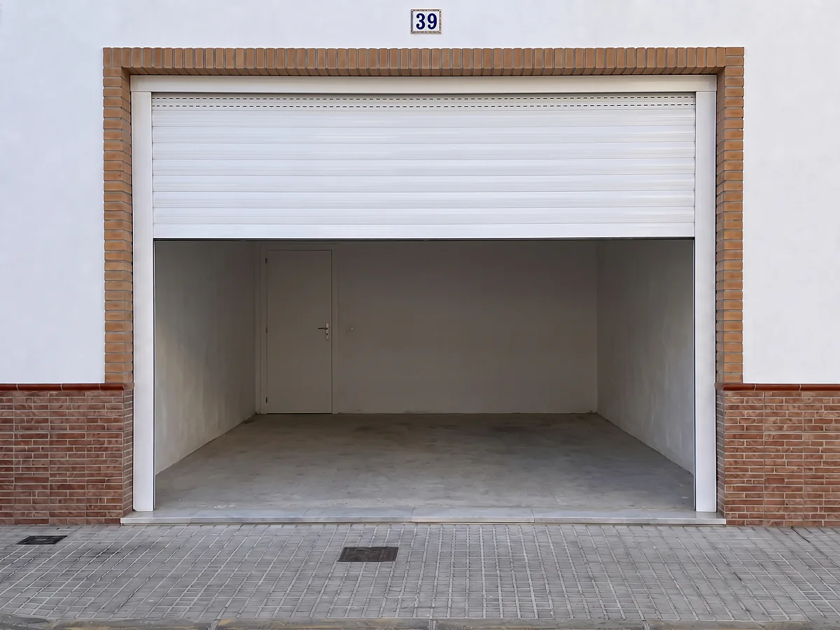 Puerta de garaje enrollable de aluminio blanco motorizada a medida en Sevilla