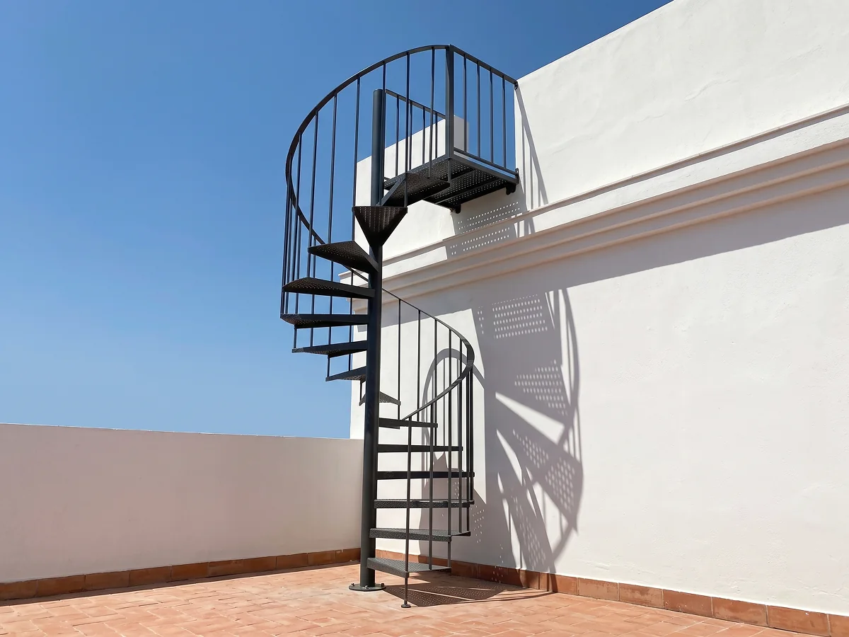 Escalera de caracol de hierro para exterior en terraza de vivienda en Sevilla