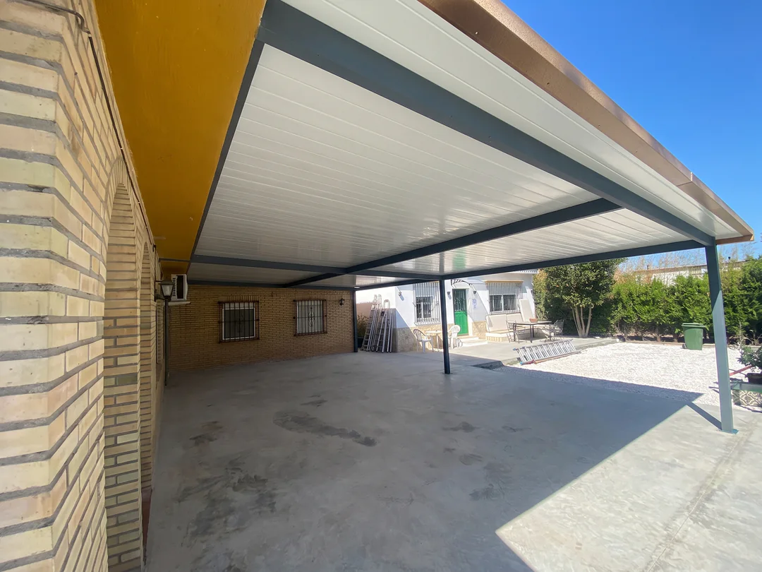 Instalación de cubierta de panel sándwich aislante en porche de patio sevillano