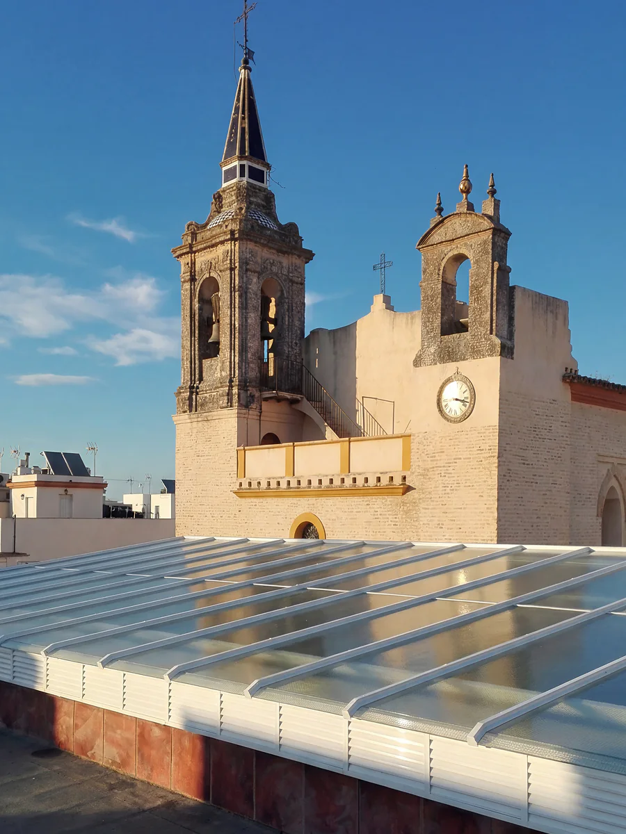 Gran cubierta acristalada en azotea de edificio en Sevilla con vistas a campanario histórico