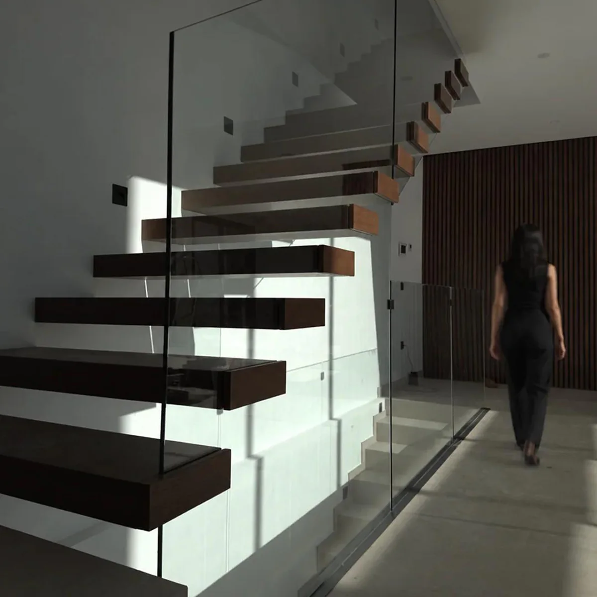 Escalera volada con peldaños de madera y barandilla de vidrio · Madera no incluida