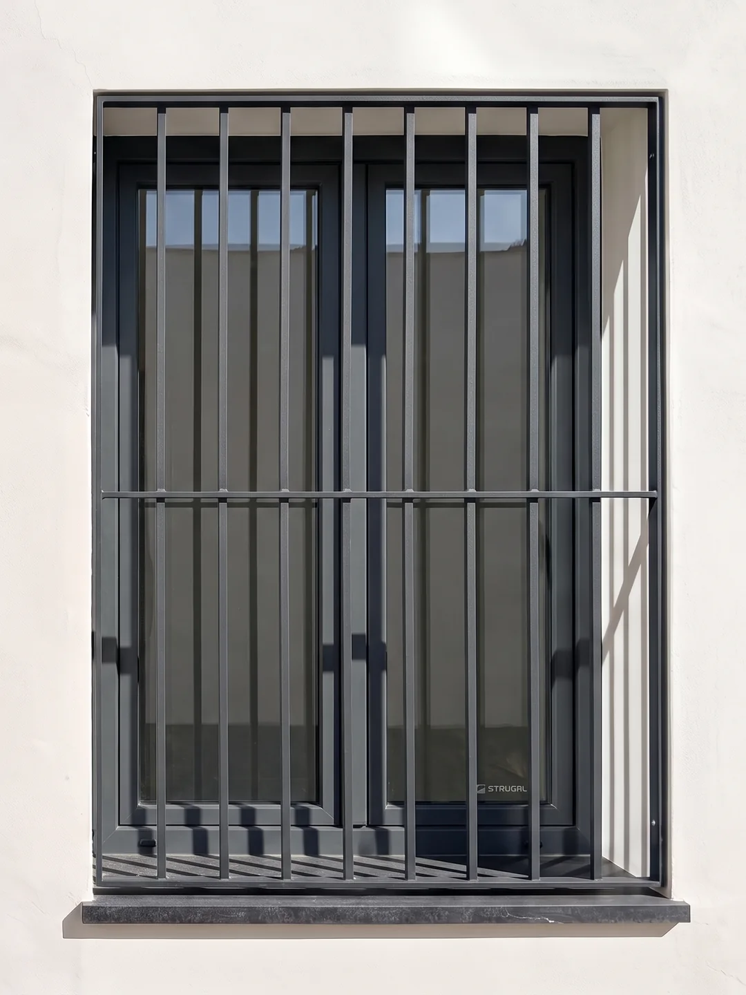 Reja de protección de diseño contemporáneo integrada en ventana de fachada en Sevilla