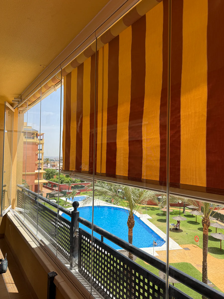 Terraza con cortinas de cristal panorámicas y vistas a la piscina en Sevilla