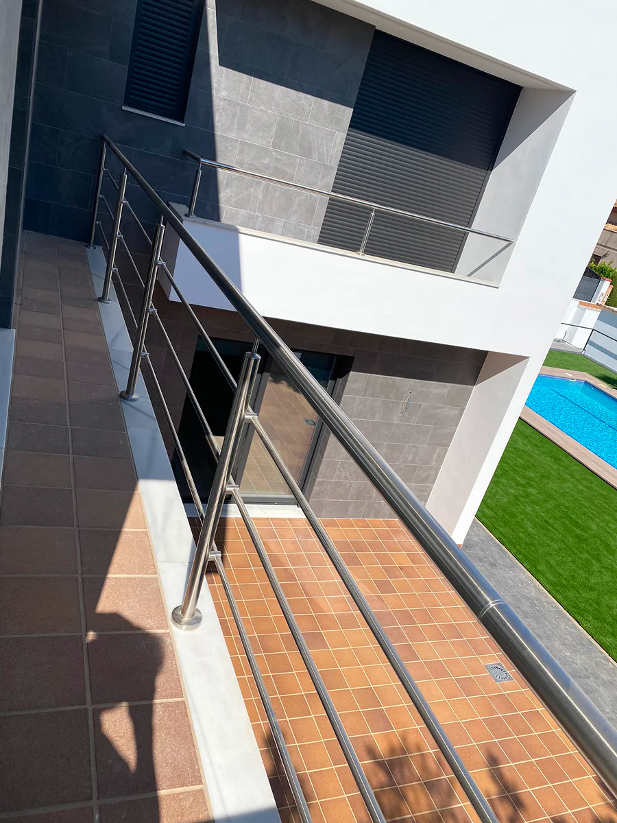 Barandilla de acero inoxidable con pasamanos tubular en terraza sobre piscina