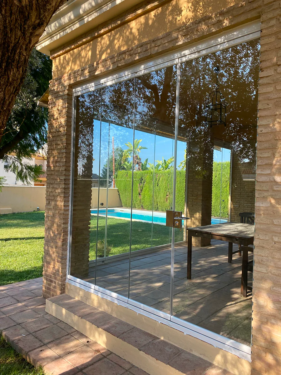 Cerramiento de terraza con vidrios de seguridad junto al jardín en Sevilla