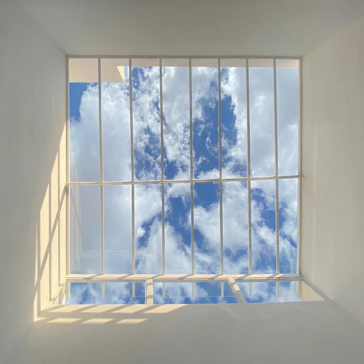 Montera de aluminio y vidrio sobre patio para ganar luz natural en Sevilla