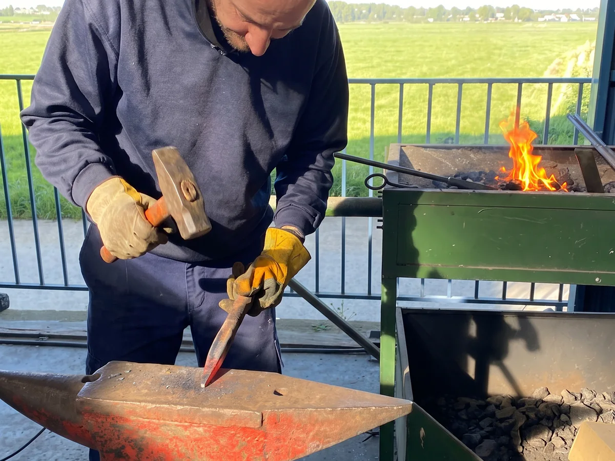 Maestro artesano de SALCOPLUS trabajando el hierro en la fragua del taller