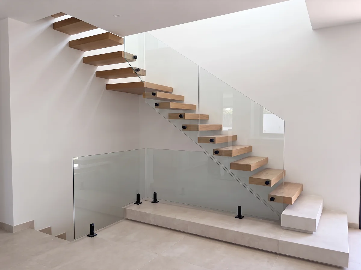 Escalera con peldaños volados flotantes y barandilla de vidrio · Madera no incluida