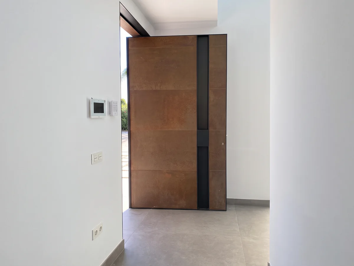 Puerta pivotante de hierro a medida para vivienda en Sevilla