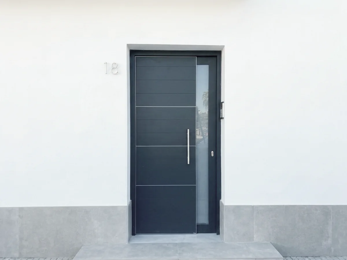 Puerta de entrada de aluminio negra a medida en Sevilla